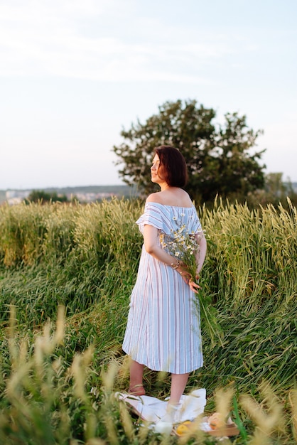 Beautiful young woman in summer in a wheat field