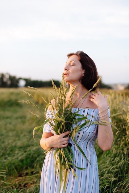 Beautiful young woman in summer in a wheat field