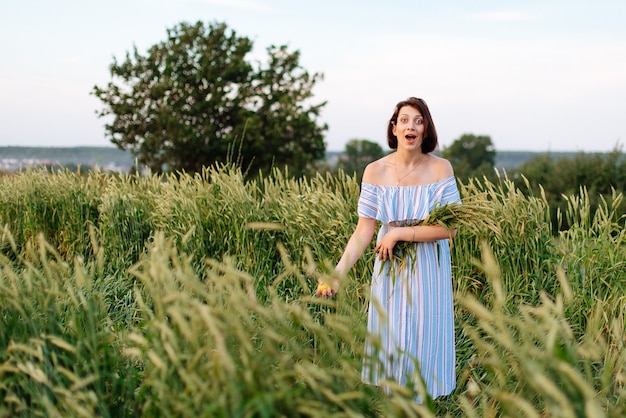 Beautiful young woman in summer in a wheat field