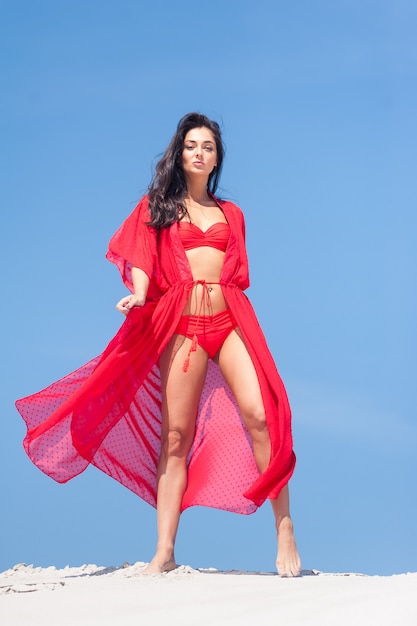 Beautiful young woman in a swimsuit on a sandy beach