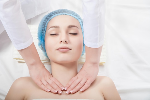 Beautiful young woman undergoing a massage Isolated over white background