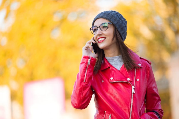 Beautiful young woman using her mobile phone in the city.