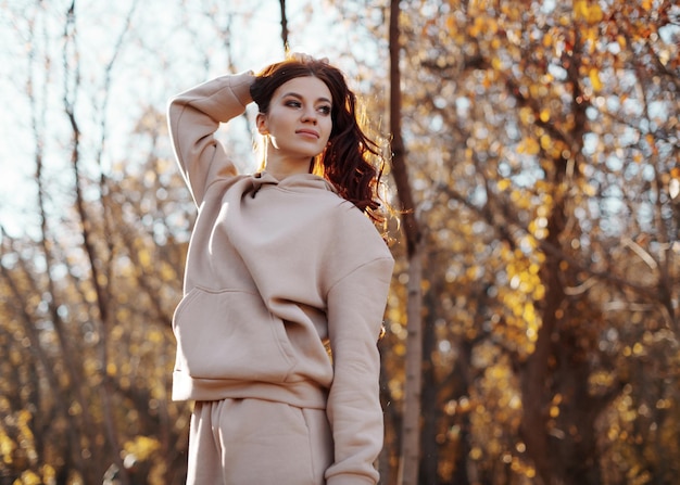 Beautiful young woman walking outdoors in sunny park