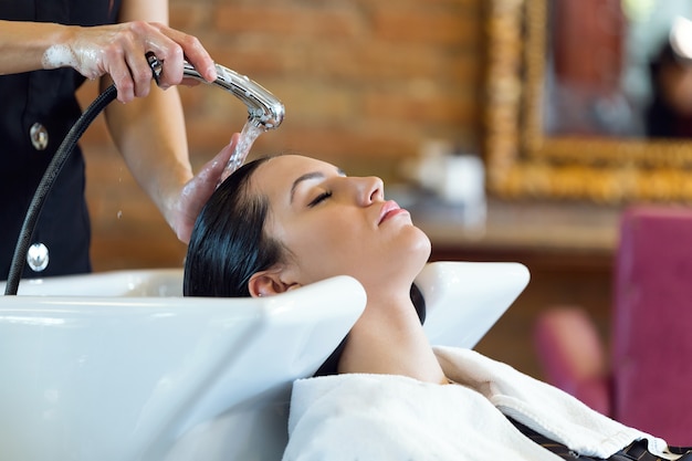 Beautiful young woman washes hair in a beauty salon.