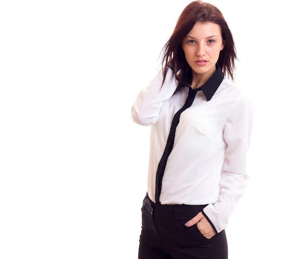 Beautiful young woman in white shirt and black trousers with dark hair on white background in studio