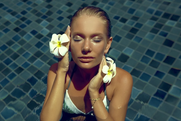 beautiful young woman with blue eyes in the pool