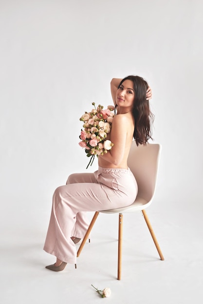 Beautiful young woman with bouquet flowers of roses International Women's Day