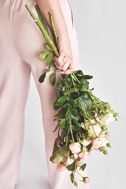 Beautiful young woman with bouquet flowers of roses International Women's Day