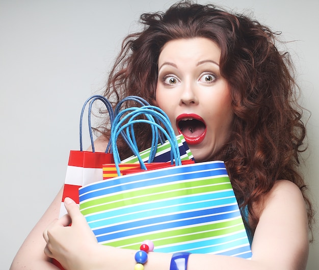 Beautiful young woman with colored shopping bags