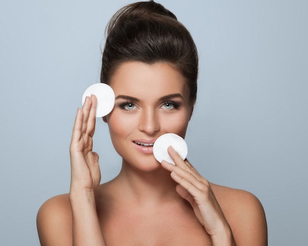 Beautiful young woman with a cotton pads