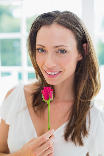 Beautiful young woman with flower at home