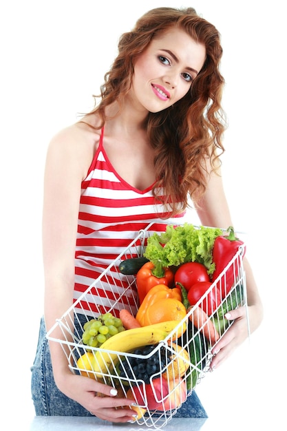 Beautiful young woman with fruits and vegetables in shopping