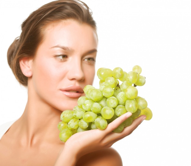 Beautiful young woman with green grape