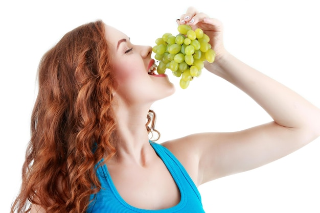 Beautiful young woman with green grape