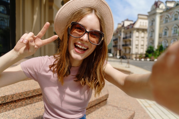 Beautiful young woman with a hat taking a selfie