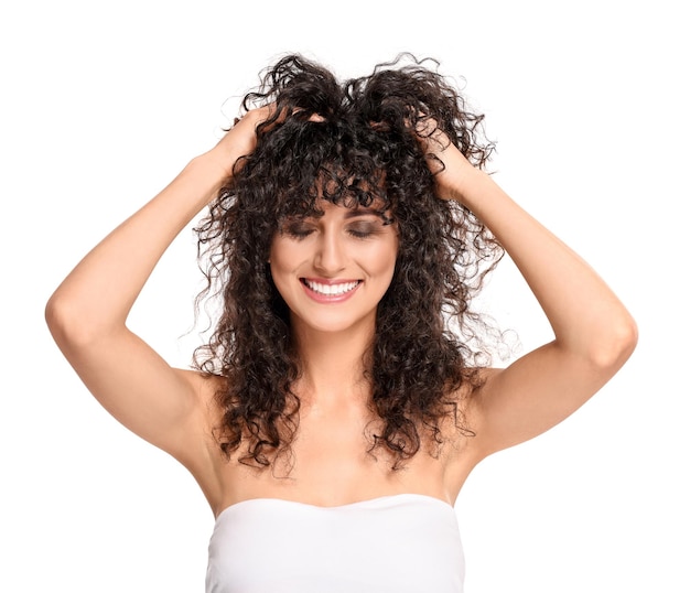 Beautiful young woman with long curly hair on white background