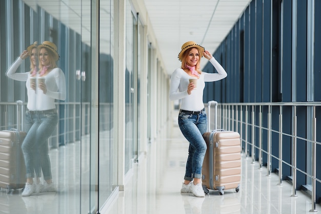 Beautiful young woman with luggage at the airport