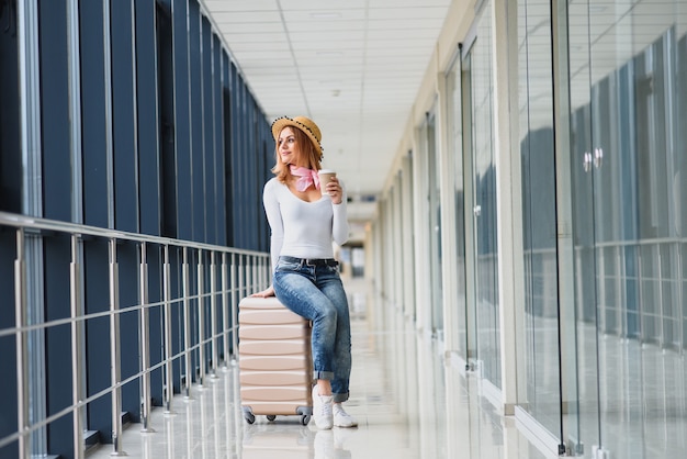 Beautiful young woman with luggage at the airport