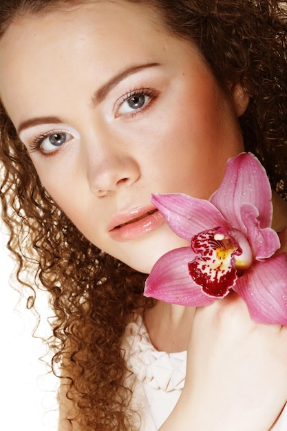 Beautiful young woman with pink orchid