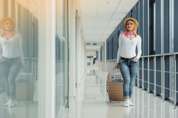 Beautiful young woman with a suitcase at the airport