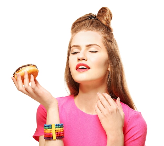 Beautiful young woman with tasty donut on white background