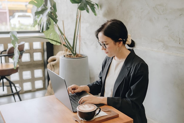 Beautiful young woman working on a laptop in cafe