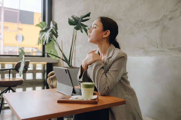 Photo beautiful young woman working on a laptop in cafe