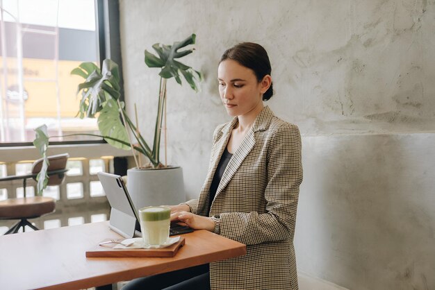 Beautiful young woman working on a laptop in cafe