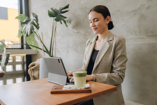 Beautiful young woman working on a laptop in cafe