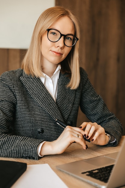 Beautiful young woman working using laptop computer, concentrated and serious, good responsible office worker.