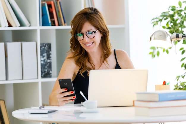 Beautiful young woman working with her laptop at home.