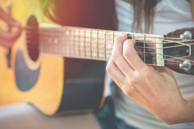 Beautiful young women are practicing to play the guitar