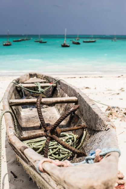 Beautiful Zanzibar coast line. Wooden fisherman boat on sandy beach with blue water background, Zanz