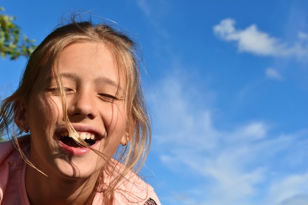 Beautifulgirl on background of clear blue sky in the summer.