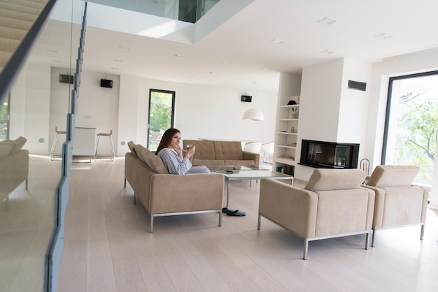 Beautifull young woman in a bathrobe enjoying morning coffee in her luxurious home villa