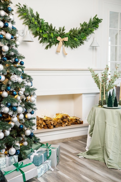 A beautifully decorated bright room for the New Year Christmas tree gifts under the tree the fireplace is decorated with garlands