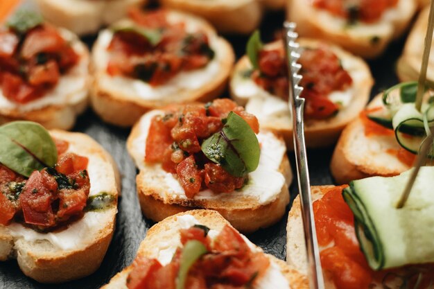 Beautifully decorated catering banquet table with different food snacks and appetizers with sandwich