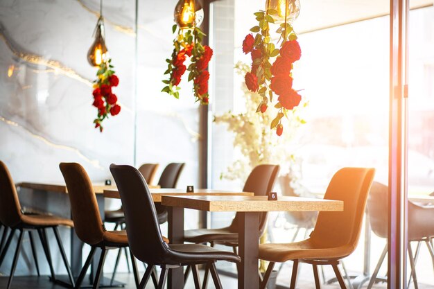 Photo a beautifully designed restaurant interior showcasing a modern and elegant dining area the space features contemporary furniture including wooden chairs and tables set with glassware plates