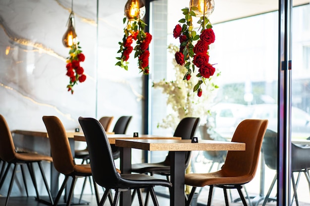 A beautifully designed restaurant interior showcasing a modern and elegant dining area The space features contemporary furniture including wooden chairs and tables set with glassware plates