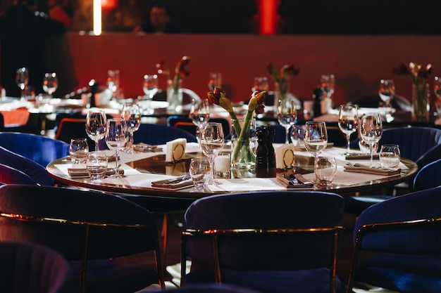 Beautifully organized event round served table banquet ready for guests round decorated table with empty plate glasses forks napkin Elegant dinner table