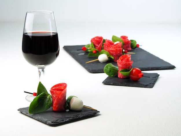 Beautifully served appetizer on skewers and a glass of red wine