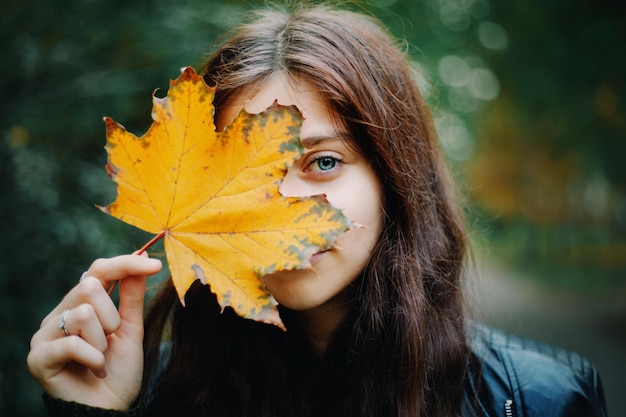 Beautuful Girl with long hair in autumn park. Close-up girl portrait