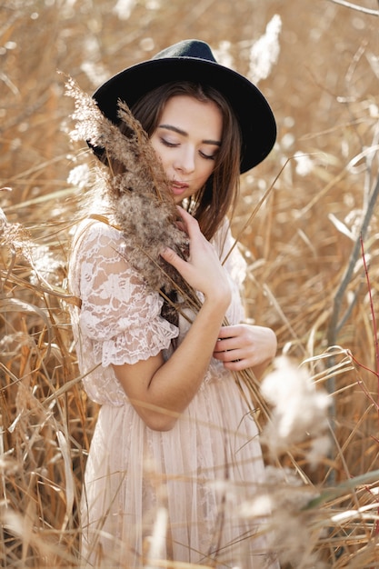 beauty art portrait of woman in field with tall grass, fashion model with clean skin natural cosmetics and makeup