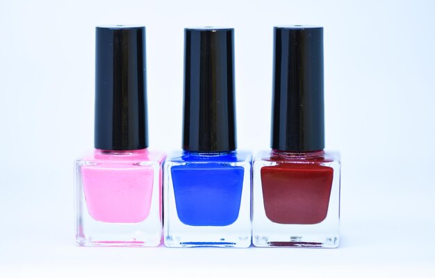 Beauty and care concept. Nail polish white background. Manicure salon. Durability and quality of nail polish coating. Gel polish modern technology. Fashion trend. Nail polish bottles different colors.