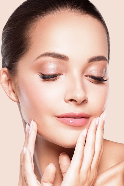 Beauty concept woman portrait over pink background. Studio shot.