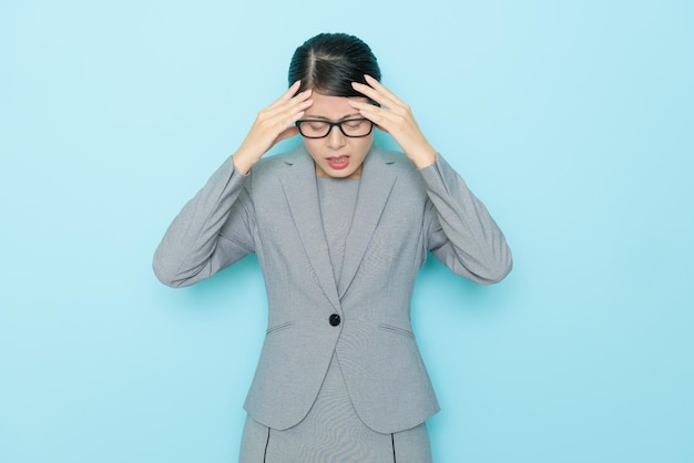 beauty elegant lawyer woman having working problem and feeling uncomfortable because she getting headache isolated on blue background.