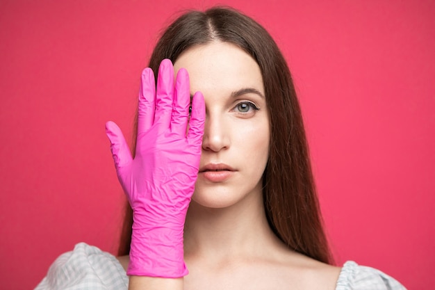 Beauty Face Skin Care. Beautiful Woman Face with hand in gloves near face