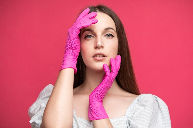 Beauty Face Skin Care. Beautiful Woman Face with hands in gloves near face