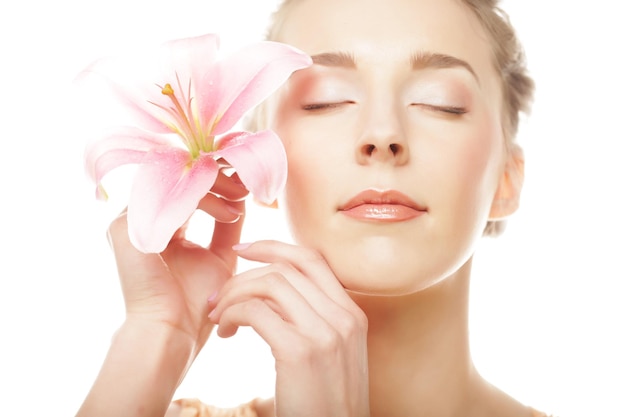 Beauty face of the young woman with pink lily