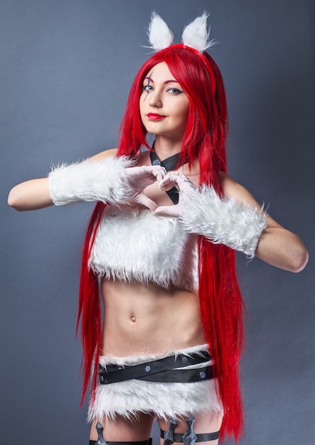 Beauty Fashion Model Girl with red wig on gray background. Cosplay Character from game